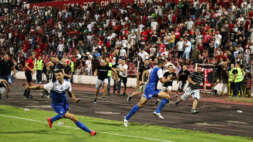 Jugadores del equipo de fútbol israelí Ashdod (azules) huyen por el ataque de aficionados de un equipo búlgaro.