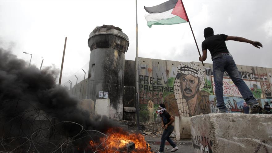 Palestinos lanzan piedras contra militares israelíes.