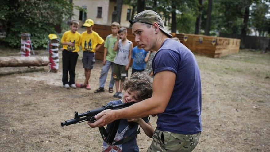 Un neonazi ucraniano entrena a un niño para disparar