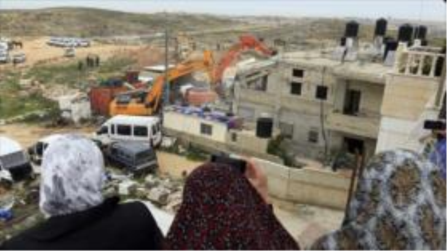 Fuerzas israelíes demoliendo con maquinaria pesada una vivienda palestina en Cisjordania ocupada.