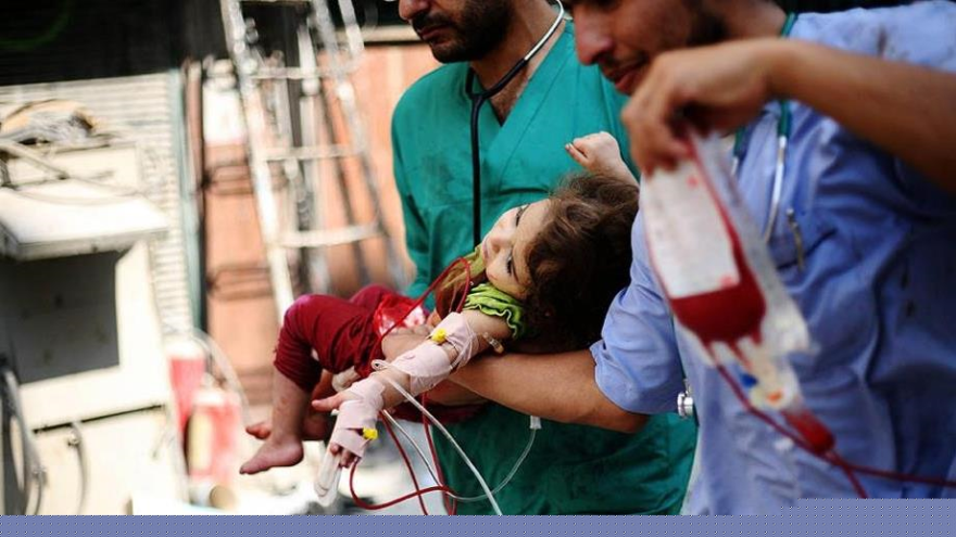 Médicos inyectan sangre a una niña palestina herida en los ataques israelí contra Gaza en 2014.
