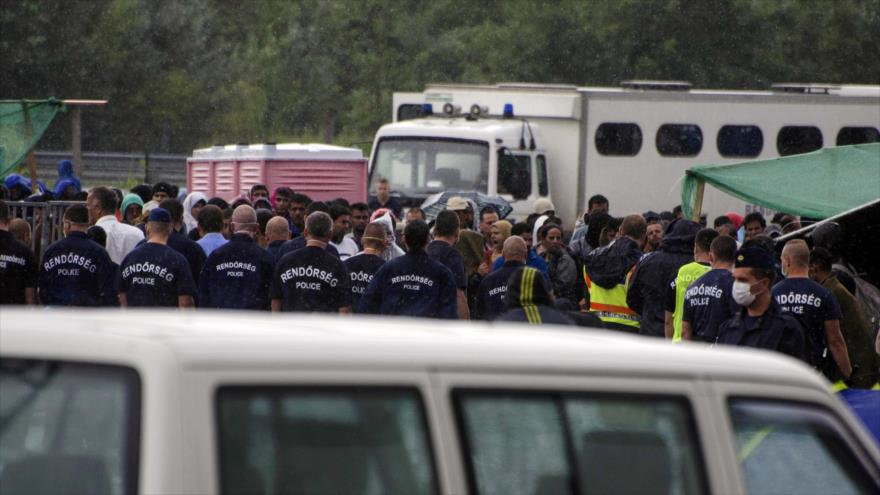 Oficiales de policía húngaros están en guardia en el campamento de refugiados de Roszke, en la frontera de Hungría con Serbia, 26 de agosto de 2015.