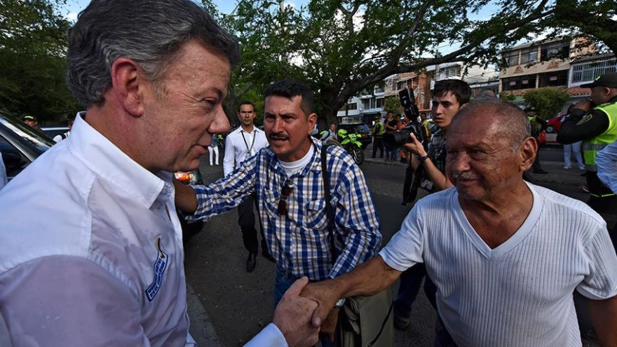 El presidente de Colombia, Juan Manuel Santos, atiende a uno de sus compatriotas deportado desde Venezuela y refugiado en la zona fronteriza en Cúcuta, 600 km al noreste de Bogotá (la capital). 29 de agosto de 2015