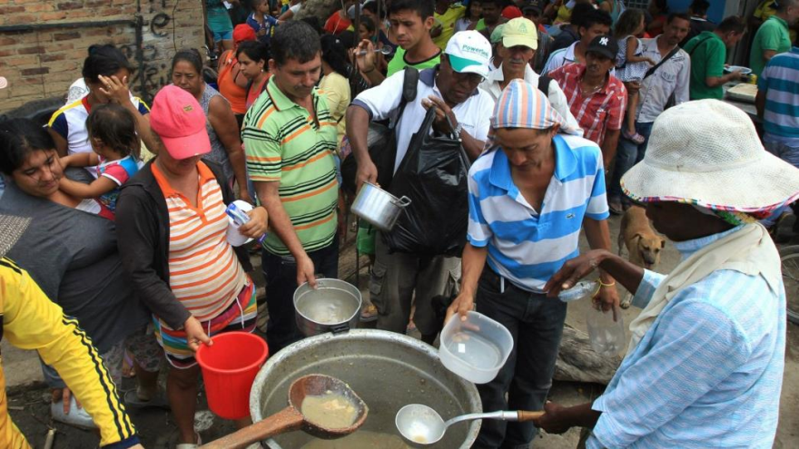 Colombianos deportados desde Venezuela preparan alimentos juntos en un albergue en la localidad de Villa del Rosario.
