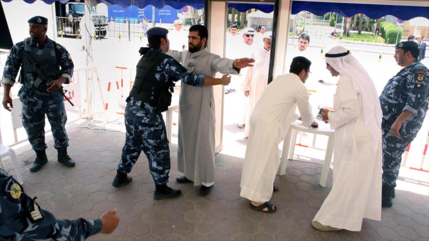 Fuerzas de seguridad de Kuwait inspeccionan a civiles.