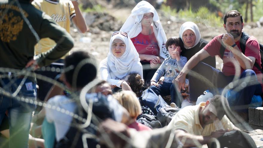 
Un grupo de los refugiados sirios esperan para cruzar a Macedonia en la frontera entre Grecia y Macedonia. 24 de agosto de 2015
