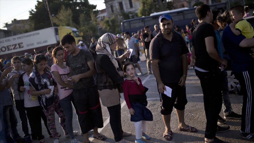 Refugiados hacen cola en un puesto de control de la Policía griega en el Puerto de Lesbos, 4 de septiembre de 2015.