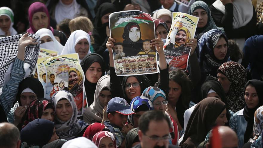 Una mujer palestina sostiene una foto de Riham Daubasha, madre del bebé de 18 meses que fue quemado vivo por los colonos israelíes. 7 de septiembre de 2015.