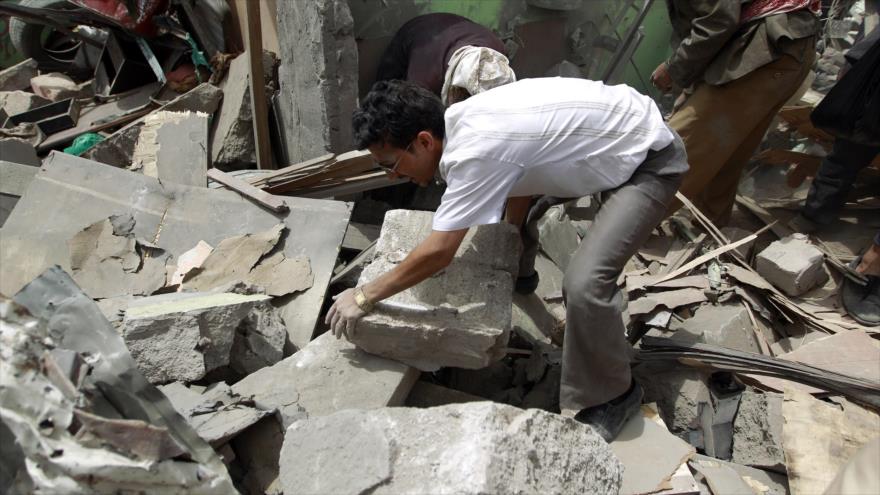 Un ciudadano yemení busca supervivientes bajo los escombros tras ataque aéreo saudí en una zona residencial en Saná, capital de Yemen.