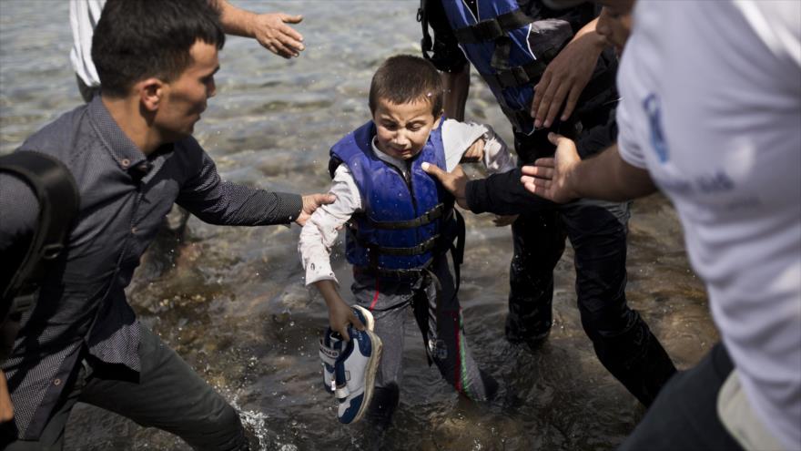 Un niño desplazado afgano llora cuando llega a las costas de la isla griega de Lesbos tras cruzar el mar Egeo desde Turquía en un bote. 9 de septiembre de 2015