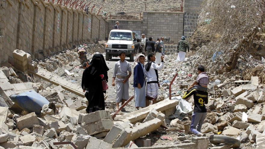 Varios yemeníes caminan entre los escombros de unos edificios destruidos en la capital del país, Saná, a raíz de los ataques aéreos de la llamada coalición árabe contra Yemen. 6 de septiembre de 2015.