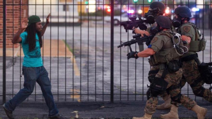 Las fuerzas policiales caminan hacia un afroamericano durante las protestas en Ferguson (Misuri, en el centro este de Estados Unidos)