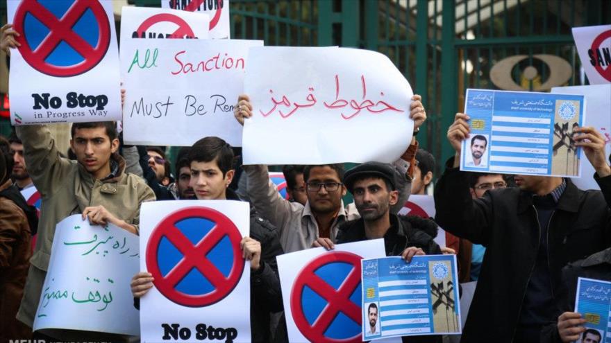 Estudiantes universitarios en Teherán, capital iraní, celebran un mitin en el que exigen la retirada de todas las sanciones antiraníes y el desarrollo del programa de energía nuclear del país.