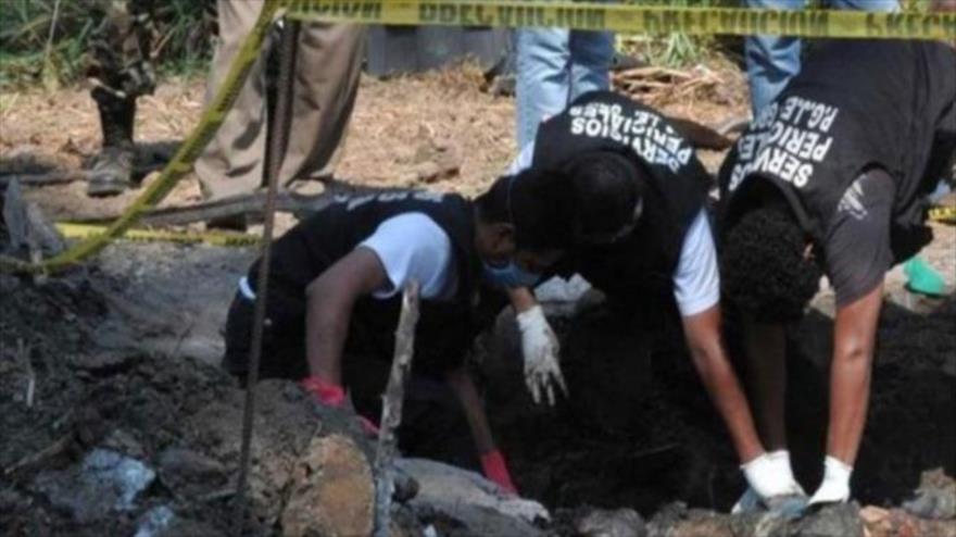 Policías inspeccionan fosa común en México.