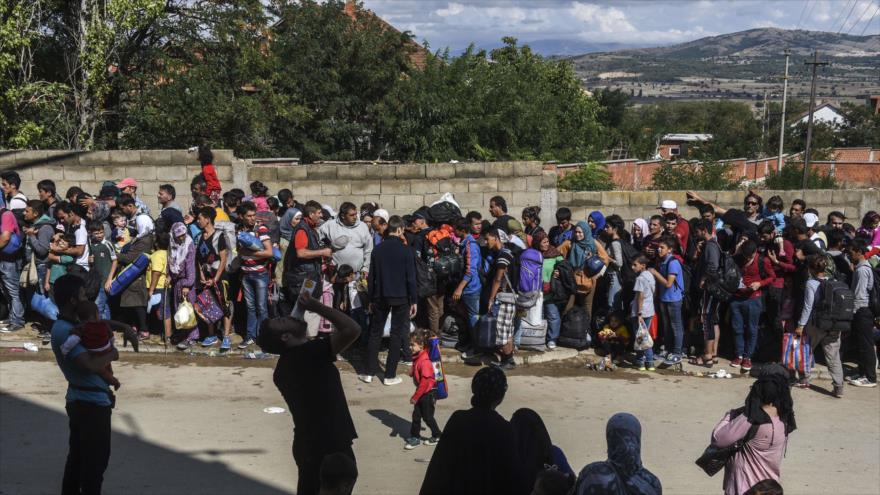 Solicitantes de asilo aguardan un autobús en el pueblo meridional serbio de Miratovac, junto a la frontera con Macedonia, 11 de septiembre de 2015.
