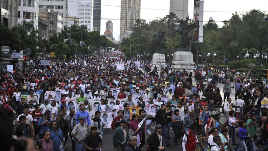 Padres de los 43 estudiantes desaparecidos portan las fotos de sus seres queridos durante una manifestación en la capitalina Ciudad de México, 26 de agosto de 2015.
