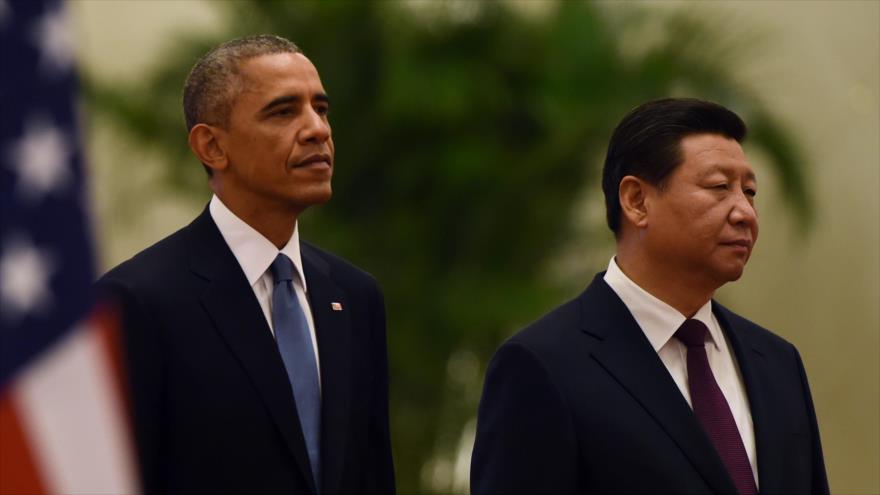 El presidente de EE.UU., Barack Obama (izda.), y el presidente de China, Xi Jinping, escuchan el himno nacional chino durante una ceremonia de bienvenida en el Gran Palacio del Pueblo en Pekín.