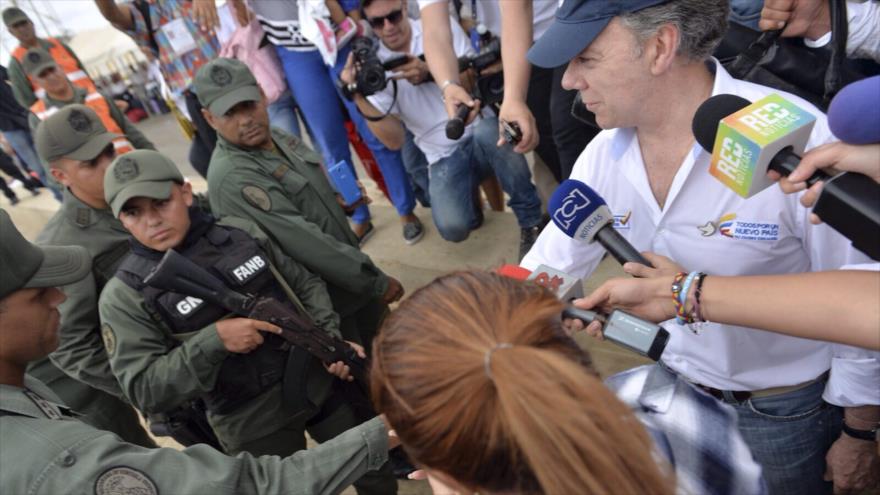 Presidente de Colombia, Juan Manuel Santos (dcha.), saluda con la mano a un miembro de la Guardia Nacional de Venezuela en Paraguachón, departamento de La Gaujira. 15 de septiembre de 2015