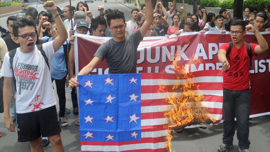 Estudiantes filipinos queman la bandera de EE.UU. durante una protesta organizada frente a la embajada de EE.UU. en la ciudad capitalina de Manila. 11 de septiembre de 2015