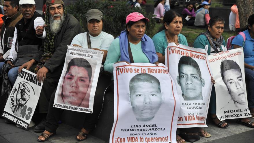 Los padres de los 43 estudiantes normalistas desaparecidos en México sostienen pancartas en frente del Palacio Nacional en la Ciudad de México, 26 de agosto del 2015.