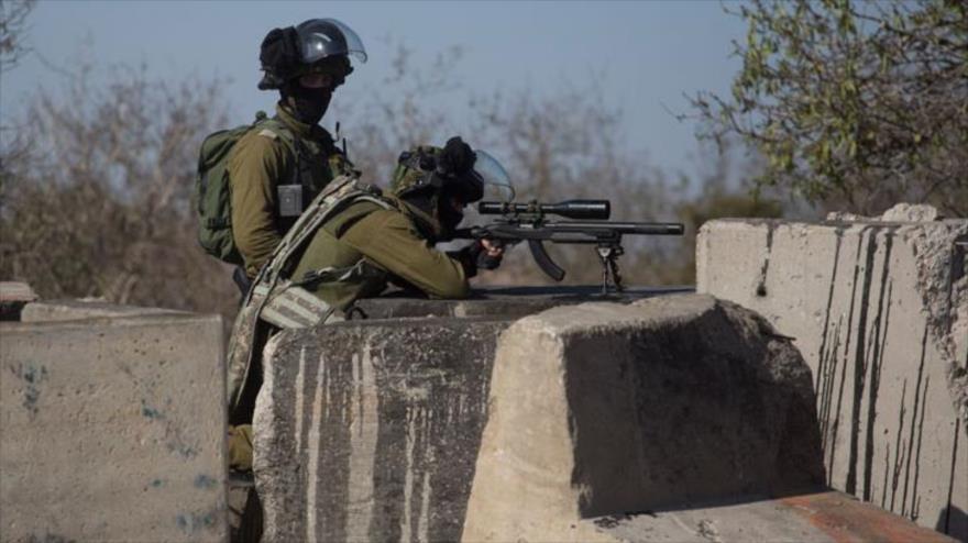 Un francotirador israelí apunta con su arma contra jóvenes palestinos durante enfrentamientos en la aldea cisjordana de Silwad.