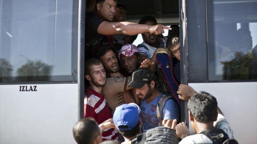 Los refugiados intentan coger un autobús fletado por el Gobierno de Croacia en la ciudad fronteriza de Tovarnik.