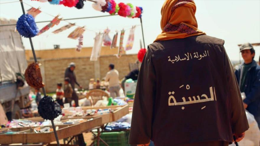 Un miembro de EIIL patrulla en un mercado en la ciudad siria de Al-Raqa