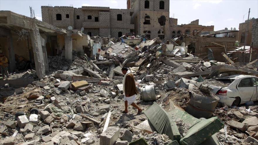 Un hombre camina entre los escombros de un edificio destruido en los bombardeos saudíes en la capital yemení (Saná).