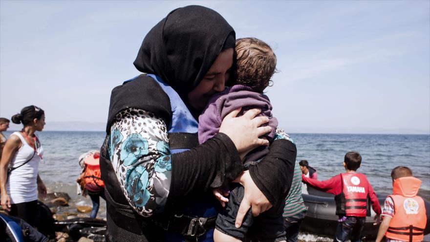 Una mujer refugiada llora mientras abraza a su hijo tras llegar a las costas de la isla griega de Lesbos.