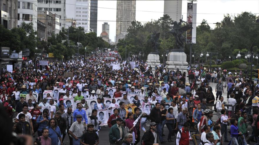 Padres de los 43 estudiantes desaparecidos portan las fotos de sus seres queridos durante una manifestación en la capitalina Ciudad de México, 26 de agosto de 2015.