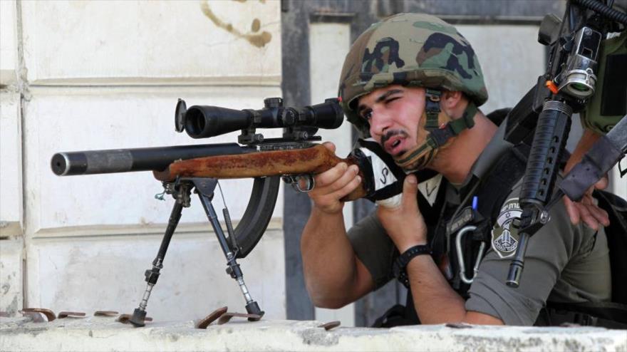 Francotirador israelí apunta contra manifestantes palestinos en Cisjordania.