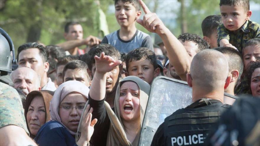 Agentes de Policía tratan de impedir a solicitantes de asilo el cruce de la frontera entre Grecia y Macedonia.