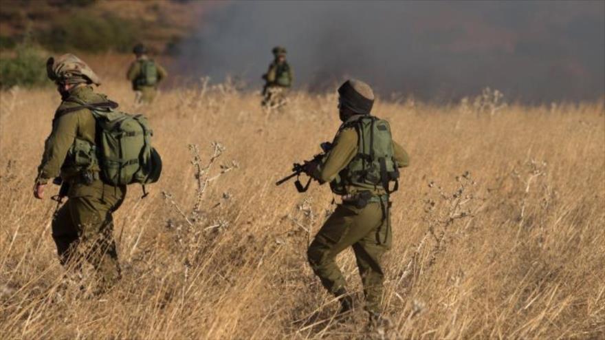 Soldados israelíes inspeccionan el lugar de la caída de un cohete en los ocupados altos de Golán.