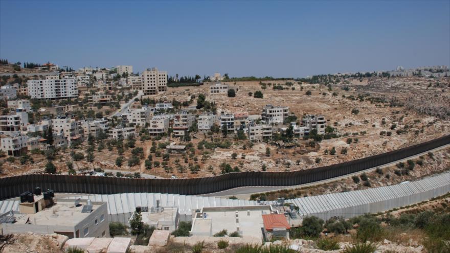 Asentamientos ilegales israelíes en los territorios ocupados de Palestina, separados con un muro de las viviendas palestinas.