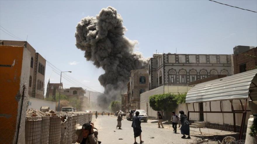 Ciudadanos yemeníes huyen tras un ataque aéreo de cazas saudíes contra un barrio en Saná, la capital del país.
