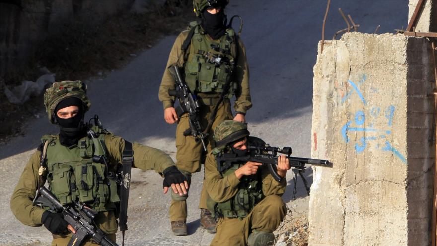 Militares israelíes apuntan contra palestinos en Nablus, en el norte de Cisjordania.