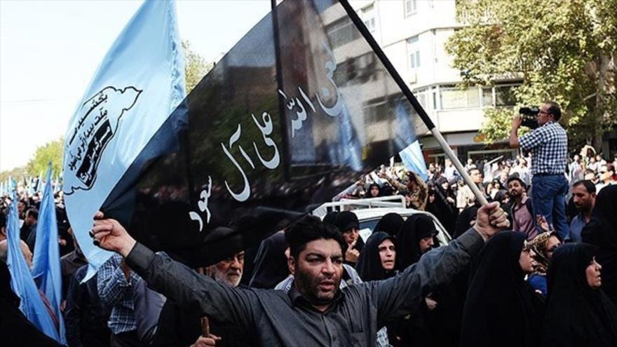 Participantes en el funeral de las víctimas de la tragedia de Mina en la capitalina ciudad de Teherán llevan banderas en las que se lee consignas contra la familia Al Saud. 4 de octubre de 2015.