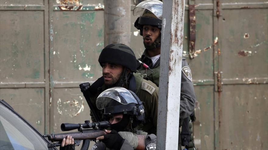 Un soldado israelí apunta su rifle contra palestinos durante los choques en Cisjordania. 6 de octubre de 2015. 