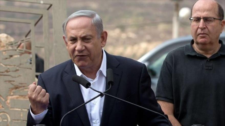 El primer ministro del régimen israelí, Benyamin Netanyahu (izda.), habla con la prensa junto a su ministro de asuntos militares, Moshe Yaalon (dcha.), cerca de la ciudad de Nablus, 6 de octubre 2015.