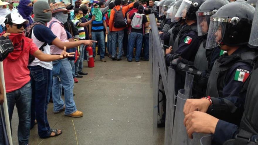 Policías federales de México impiden el paso a los manifestantes que exigen justicia en el caso de los 43 estudiantes desaparecidos.