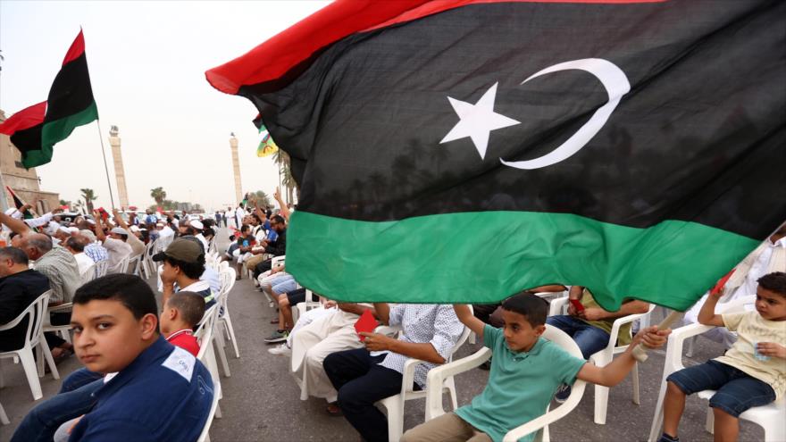 Un niño libio enarbola una bandera de su país.