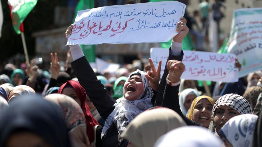 Mujeres palestinas en la ciudad de Gaza llevan pancartas durante una manifestación en apoyo a los palestinos en la ocupada Cisjordania y en contra de los colonos israelíes que visitan la Mezquita Al- Aqsa. 10 de octubre de 2015