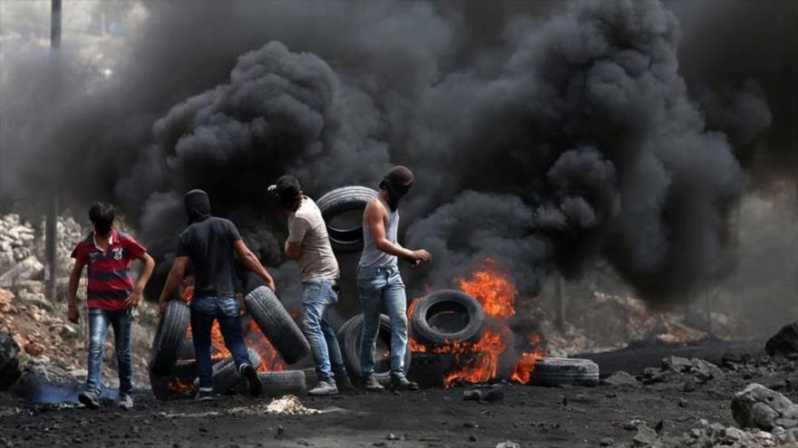Manifestantes palestinos incendian neumáticos en una manifestación antisraelí.