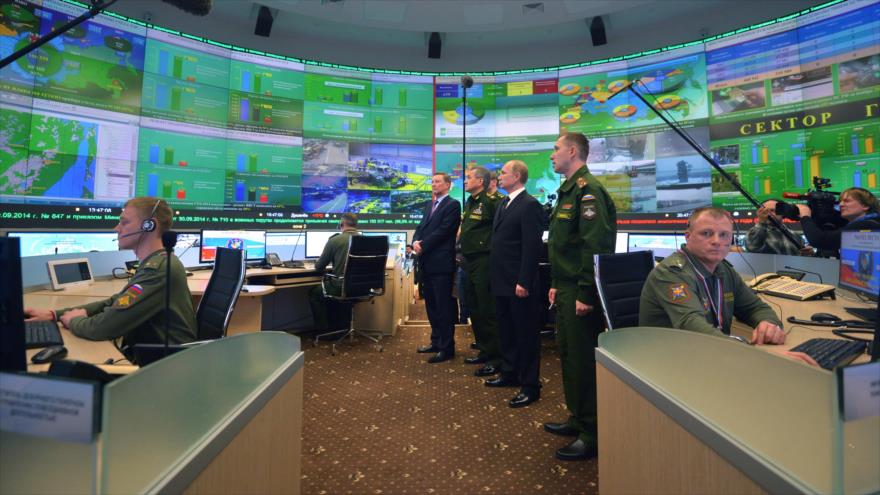 El presidente ruso, Vladimir Putin (2°dcha.), junto con el ministro de Defensa, Serguei Shoigu (3° dcha.), en la sala de control del Ministerio de Defensa, durante una reunión con funcionarios militares de alto rango en Moscú, 19 de diciembre de 2014.