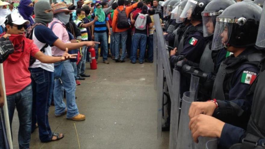 Policías federales de México impiden el paso a los manifestantes que exigen justicia en el caso de los 43 estudiantes desaparecidos.
