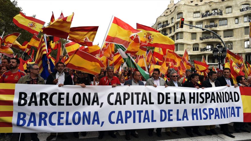 Manifestantes en contra de la independencia de Cataluña sostienen una pancarta en frente del edificio de La Pedrera en Barcelona (noroeste), durante una manifestación por la unidad del país con motivo del Día Nacional de España (Dia de la Hispanidad), el 12 de octubre del 2015.