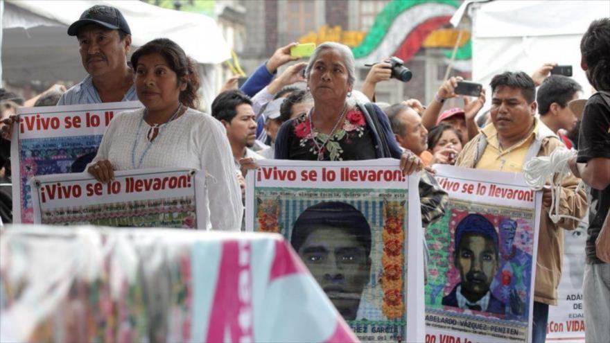 Padres de los 43 estudiantes desaparecidos en México llevan las fotos de sus hijos durante una marcha en el primer aniversario de la tragedia. 26 de septiembre de 2015