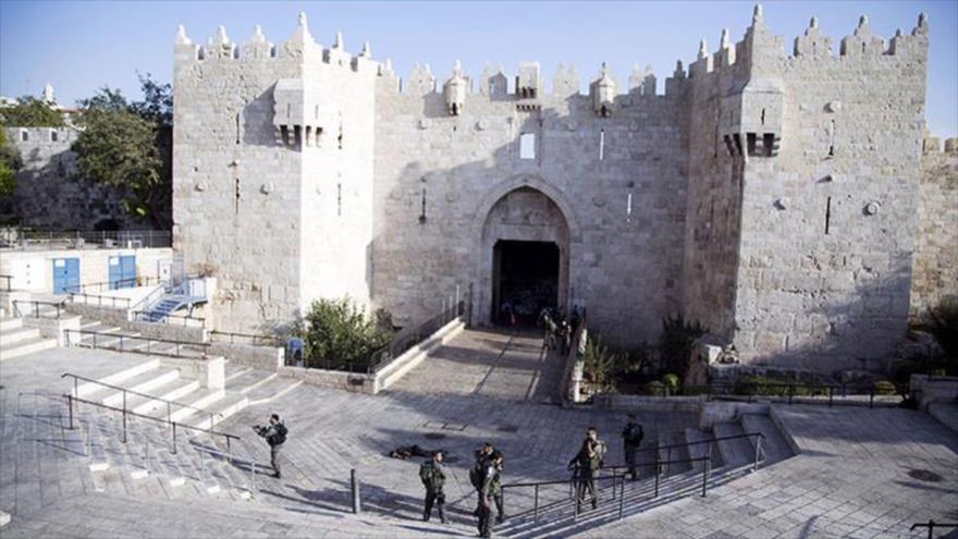 Los policías israelíes al lado del cadáver de un joven palestino abatido a tiros cerca de la Puerta de Damasco, en Jerusalén, 14 de octubre de 2015.