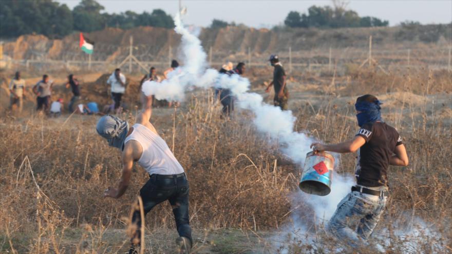 Manifestantes palestinos en medio de humos de gases lacrimógenos lanzados por soldados israelíes, 15 de octubre de 2015.