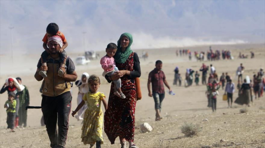 Los desplazados de la secta minoritaria izadi huyen de la violencia causada en la ciudad de Sinjar (norte de Siria).